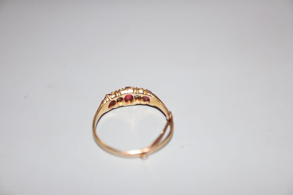 A yellow metal, ruby and diamond set five stone half hoop ring, size P, gross weight 2.2 grams.